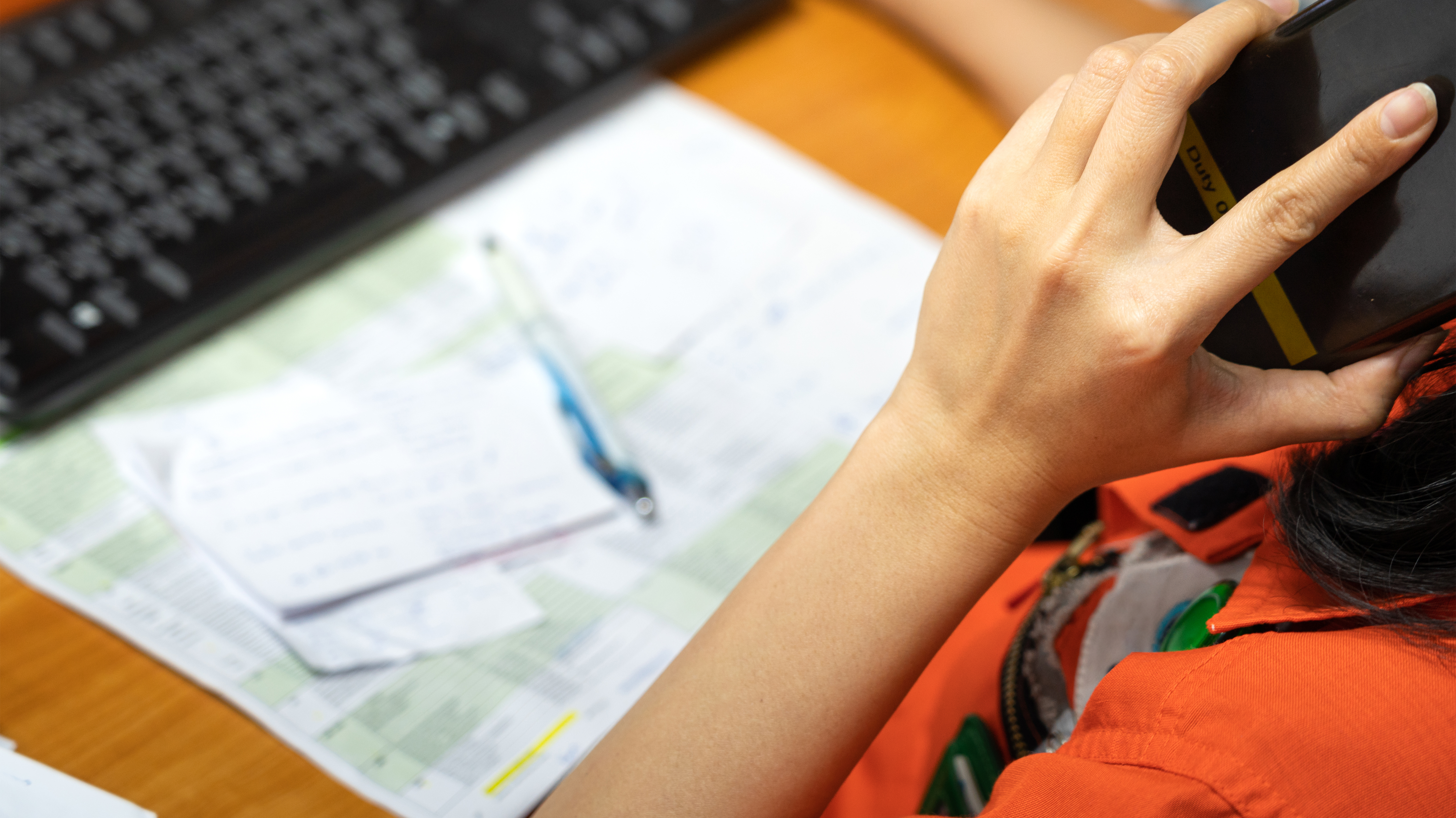 person holding phone at desktop working on crisis case